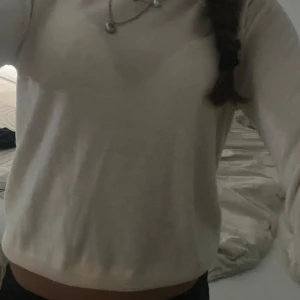 Vit långärmad tröja i bomull - Enkel och stilren vit långärmad tröja i mjuk bomull. Tröjan har rund halsringning och en klassisk passform som funkar till många olika outfits. Perfekt för dig som gillar en clean och basic look.