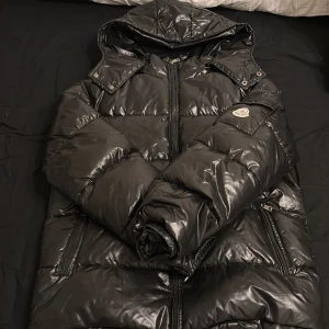 Svart Moncler Maya jacka - Säljer denna svarta Moncler Maya jackan som är använd lite men inte såpass mycket, scan funkar och är väldigt fin. Storleken är mellan M och L passar båda, väldigt snygg till sommar kvällarna!