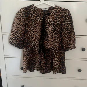 Leopardmönstrad blus med puffärm och rosett - Säljer en snygg leopardmönstrad blus med puffiga korta ärmar! Använd endast en gång. Storlek xs från Only