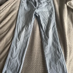  jeans från Flash Jeans - Säljer ett par jättesnygga  blåvitrandiga jeansbyxor från Flash Jeans. Byxorna har klassisk femficksdesign, raka ben och stängs med knapp och dragkedja. 
