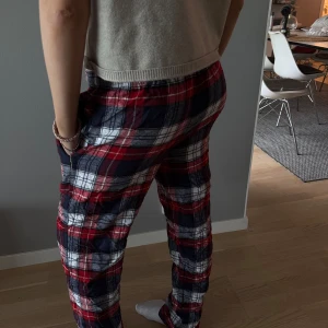 Rödblå rutiga mjukisbyxor med snörning - Säljer ett par mjuka och sköna mjukisbyxor med röd, blå och vit rutig design. Byxorna har resår och snörning i midjan för extra komfort. 