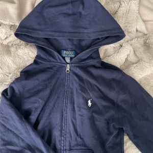 Ralph Lauren zip up - Marinblå Ralph lauren zip up, knappt använd. Storlek 10-12 år, men är stor i storleken. Köpte på kidsbrandstore för 1200kr