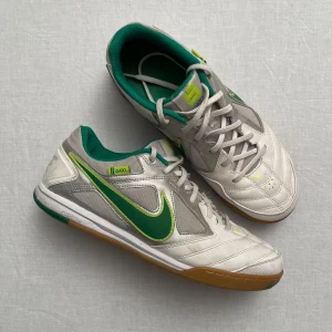 Nike gato skor  - Säljer ett par riktigt snygga inomhusskor från Nike. Skorna har en unik vintage design med snörning och en slitstark gummisula. Perfekta för inomhusbruk men funkar perfekt som vanliga utomhusskor också. De är i bra skick. Strl 43