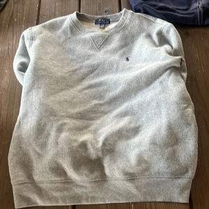 Grå sweatshirt från ralph lauren kom med pris förslag - Klassisk grå sweatshirt från Polo Ralph Lauren med rund halsringning och broderad logga på bröstet. Tröjan har en enkel och stilren design, perfekt för en avslappnad look. Mjuk och bekväm bomullsblandning.pris går att diskutera vid snabb affär 