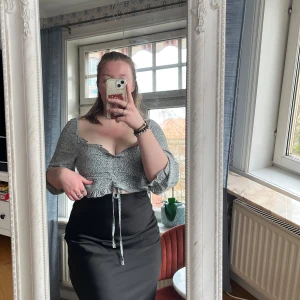 Mönstrad drawstring top - Säljer en blåvit drawstring top med knytband i midjan och små vita prickar över hela tyget. Topen är i ett lätt, mjukt material som känns skönt mot huden och har en dragkedja på sidan. Perfekt för dig som gillar en söt och trendig stil!