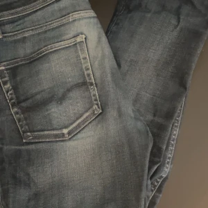 Mörkblå jeansbyxor med slitningar - Säljer ett par mörkblå jeansbyxor från Jack and Jones  strlk 30/32  i bra skick pris kan diskuteras dessa passar mellan 160-170