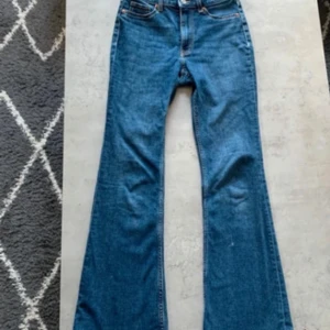 Blå bootcut jeans - Klassiska blå jeans med bootcut passform och normal midja. Jeansen har fem fickor och stängs med dragkedja och knapp. Perfekta för en avslappnad och tidlös stil.