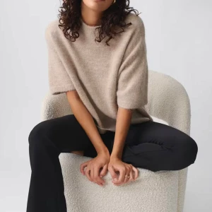 Stickad t shirt från gina - Supermjuk och fluffig beige stickad tröja från Gina med rund hals och korta ärmar. Tröjan har en avslappnad passform och ribbade kanter vid ärmslut, hals och nederkant. Ny utan prislapp och helt slutsåld online just nu🤍