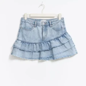 Ljusblå jeanskjol med volanger - Säljer denna ljusblå jeanskjol från Gina Tricot. Kjolen är andvänd men inga defekter. 