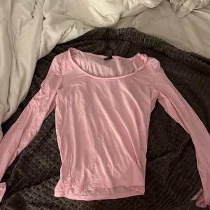 Ljusrosa långärmad topp - Säljer en ljusrosa långärmad topp med rund halsringning. Tunn och mjuk i materialet, perfekt för lager-på-lager eller som enkel baströja. Passformen är normal och toppen är enkel att matcha till olika outfits.