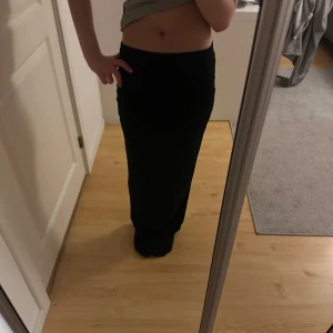 Lång tajt kjol  - En lång svart tajt kjol från Gina tricot. Vid sidorna av kjolen är det som band så att den blir tajtare (sida 4). Jag är 156 cm och på mig är kjolen ner under hälarna!! Även ett märke på sidan längst upp pågrund av att jag satt en tofs då kjolen var för lång (syns inte så mycket när den är på🥰