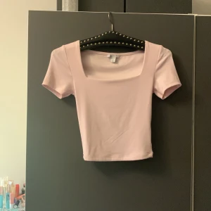 Ljusrosa kortärmad topp från Amisu - Säljer en söt ljusrosa topp från Amisu. Den har en fyrkantig urringning och korta ärmar. Perfekt för en stilren look. Tillverkad i ett mjukt material som känns skönt mot huden.