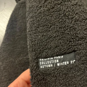 Svart fleece hoodie från Frilivin Paris - Mysig svart fleece hoodie från Frilivin Paris Collection Autumn/Winter 21. Tröjan har en dragkedja framtill och en stor ficka på magen. Perfekt för kyliga dagar! Nypris någea tusen minns ej exakt.