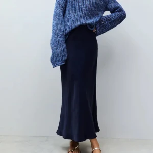 Mörkblå långkjol från Design By Si - Elegant satin kjol i midilängd från Design by Si och av märket Eight Paris.   Den har en smickrande silhuett och en vacker, mörkblå färg. Perfekt för både vardag och fest. Kombinera den med en stickad tröja för en avslappnad look eller med en blus för ett mer formellt tillfälle.   Den vita stickade mohair tröjan är fantastisk fin till och finns till salu på min sida. Helt ny den också!  