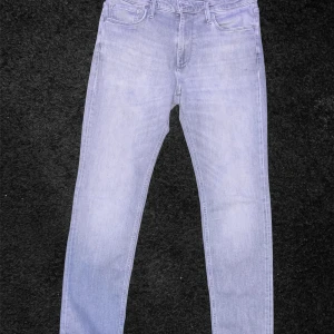 Ljusblå jeans från Jack & Jones - Snygga gråa jeans från Jack & Jones i modellen Regular Clark. De har en klassisk femficksdesign och en bekväm passform. Perfekta för en avslappnad stil.