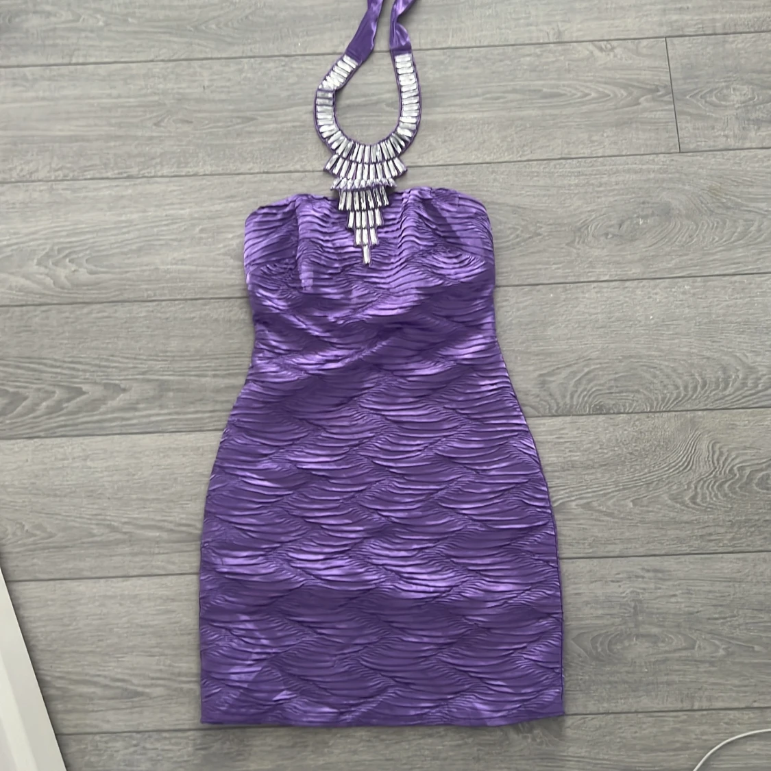 Lila axelbandslös klänning med smyckesdetalj