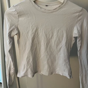 Vit långärmad topp - Säljer en enkel och stilren vit långärmad topp. Perfekt för lager-på-lager eller att bära som den är. Den har en rund halsringning och är tillverkad i ett mjukt material.
