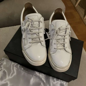 Giuseppe Zanotti skor - Snygga vita sneakers från Giuseppe Zanotti. Perfekta för en stilren look. Skorna har en rund tå och är tillverkade i skinn. Hör gärna av er vid frågor och funderingar! 
