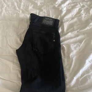 Svarta jeans från Replay - Snygga svarta jeans från Replay med en modern passform. De har en klassisk femficksdesign och en diskret logga på bakfickan. Perfekta för en stilren look.