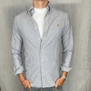 Grå skjorta från Polo Ralph Lauren - Säljer en stilren grå skjorta från Polo Ralph Lauren i slim fit. Storlek S. Skjortan är i mycket bra skick och endast använd ett fåtal gånger. Säljer för endast 300 kr! Nypris ca 1350 kr. Skriv vid frågor och funderingar.
