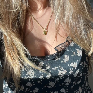 Svart blommig linne med spetsdetaljer - Säljer ett svart linne med blommigt mönster och spetsdetaljer vid halsringningen. Perfekt för sommaren och är så så fin! 💌Passar M storleksordning 