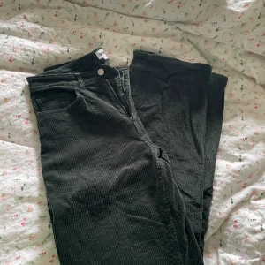 Svarta manchesterbyxor från Weekday - Säljer ett par svarta manchesterbyxor från Weekday. Byxorna har en dragkedja och knapp framtill och är tillverkade i ett mjukt manchestermaterial. Perfekta för en stilren look. Viss slitning ner till vid byxbenen. Se sista bilden. 