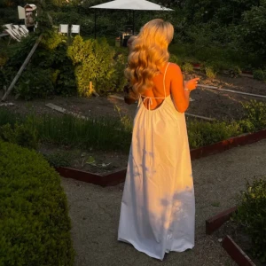 Breezy Dress White Djerf Avenue - Säljer en elegant vit långklänning från Djerf Avenue. Klänningen har tunna axelband och en öppen rygg med knytning. Orginalpris är 500 och klänningen är använd 2 gånger!