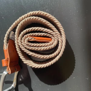 Beige flätat bälte från Jack & Jones - Snyggt beige flätat bälte från Jack & Jones med silverfärgat spänne och bruna läderdetaljer. Perfekt för att ge en stilren touch till din outfit. Passar till både jeans och chinos.