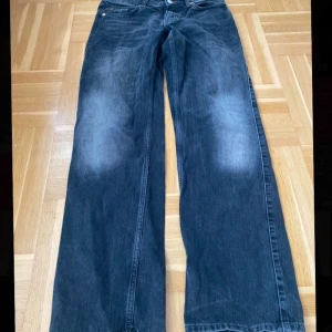 Svarta jeans från Weekday - Snygga svarta jeans från Weekday med en klassisk design. De har en rak passform och är tillverkade i ett slitstarkt denimtyg. Perfekta för en avslappnad stil.