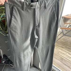 Byxor - Ljusgråa kostymbyxor/chinos ish från Jack and Jones, bra skick. Perfekta till sommaren. Passar dig som är mellan 1,70-1,75!