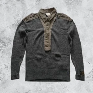 Stickad kofta från diesel - Säljer en unik grå tröja från Diesel med skjortdetaljer i olivgrön färg. Tröjan har långa ärmar och ribbade muddar. Skjortkragen och axelpartiet ger en cool kontrast och stil. Perfekt för dig som vill ha något annorlunda i garderoben!