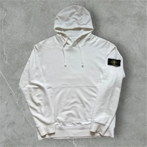 Stone Island Hoodie Vit XL - 📍Storlek: XL  💪🏽Skick: Mycket bra! Liten lagning på höger axel, och äggulorna har släppt lite på luvan. Detta märks absolut inte om man inte kollar riktigt riktigt noga.  📐Mått: Längd:73 Axelbredd: 51cm  📎  Material: 100% bomull  📦Skickar alltid inom 24h  💸Köp fler plagg för att få billigare pris  ✅Äkthetsgaranti 