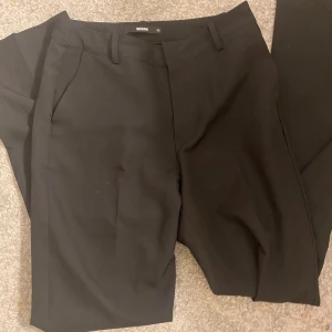 Svarta kostymbyxor från Weekday - Snygga svarta kostymbyxor från BikBok med en klassisk design. Byxorna har en rak passform och är perfekta för en stilren look. Passar mig som har strl S men säljer för de e förkorta. 