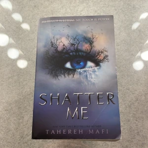 Shatter Me - Boken 'Shatter Me' av Tahereh Mafi handlar om en tonårsflicka med en dödlig beröring som hålls fången av en brutal regim. Hon kämpar för att återta kontrollen över sitt liv och sin kraft. Omslaget pryds av ett öga omgivet av trädgrenar mot en dramatisk himmel.