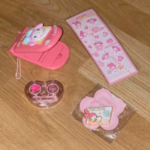 Rosa linsförvaring med spegel, My Melody-tema och Barbie 💖💖 - En söt y2k rosa sminkspegel/  linsförvaring  med My Melody-design. Det var en kollektion med ett linsmärke i Asien finns inte att köpa längre, den är kompakt och perfekt för att ha med i väskan eller ta y2k bilder📸💖. Skickar också med en Barbie tema linsförvaring( super gullig! 😵‍💫🩷), klistermärke för att dekorera my melody spegeln och en my melody brosch. Alla är nya och har aldrig använt ( linserna följer inte med 💖)