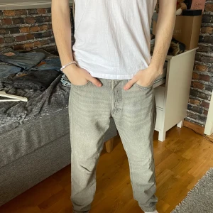 Jack and Jones jeans  - Säljer ett par grå loose fit jeans med normal passform från Jack and Jones. Byxorna har en klassisk design med fem fickor och knappgylf. Perfekta för en avslappnad stil. Storlek 29/32