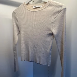 Beige ribbad tröja från Zara - Säljer en stilren beige ribbad tröja från Zara. Tröjan har långa ärmar, är i fint skick