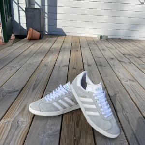 Adidas gazelle skor - Adidas gazelle skor i Storlek 43.5 ✅ Skrona är i nyskick, samt nytvättade och nya snören! Passar perfekt nu inför vår och sommar! Färgen på skorna är ljusturkos/ljusgrå