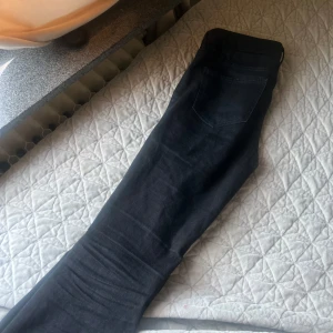 Svarta jeansbyxor - Snygga svarta jeansbyxor med en klassisk design. De har en knapp och dragkedja framtill samt fickor både fram och bak. Perfekta för en stilren look. Storleken är 164 alltså från barnavdelningen 