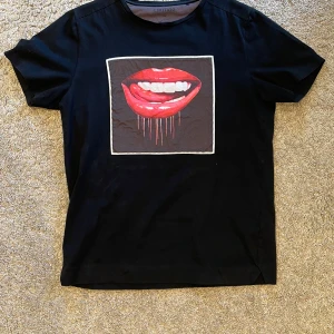 Limitato T-shirt - Snygg svart t-shirt från Limitato med ett coolt tryck av röda läppar på framsidan. Perfekt nu för våren och sommarn. Använd sparmsamt. Hör av er vid minsta fundering 😁