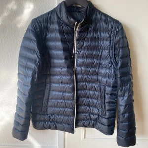 Mörkblå dunjacka från Herno - Dunjacka från Herno i så gott som nyskick. Har använt den ett fåtal gånger och den har inga defekter. Lite tunnare perfekt för våren och går även att ta loss ärmarna och ha som en väst. Storlek 50/medium. Skriv vid funderingar eller om ni vill ha fler bilder på jackan!
