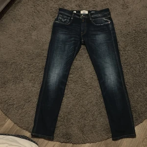 Mörkblå jeans från Replay - Snygga mörkblå jeans från Replay, modell Anbass. De har en slim fit passform och klassisk femficksdesign. Perfekta för en stilren look med snygga detaljer och slitningar.Stilrena replay jeans aldrig använda. Pris kan diskuteras vid köp!!