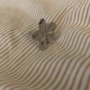 Silverfärgad blomring - Snygg och stilren ring i silverfärg med en stor blomma som detalj. Perfekt för att ge en extra touch till din outfit. Blomman har fem kronblad med fina detaljer.
