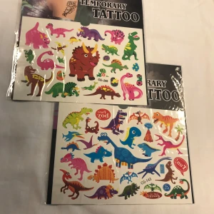 Tillfälliga tatueringar med dinosauriemotiv - Färgglada tillfälliga tatueringar med olika dinosauriemotiv. Perfekt för barnkalas eller som en rolig accessoar. Innehåller flera ark med olika dinosaurier i livliga färger som rosa, blå, grön och orange. 50kr/2st/bild , sammafrakt 
