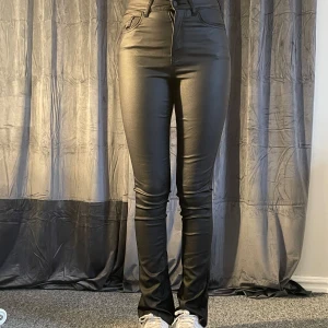 Svarta, bootcut, skinnbyxor från Gina tricot - Snygga svarta skinnbyxor från Gina tricot med hög midja. Byxorna har en klassisk design med fem fickor och dragkedja. Modellen är 167cm lång. Aldrig använda!