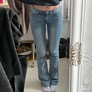 Blå tall bootcut jeans - Snygga blå bootcut jeans med en klassisk femficksdesign. De har en knapp och dragkedja framtill och är perfekta för en avslappnad stil. Jeansen har en lätt tvättad look som ger dem en trendig touch. Jätte stretchiga och bekväma att ha på sig och väldigt långa så passar oss långa tjejer, innerbenslängden är mellan 84-87 cm💓💓