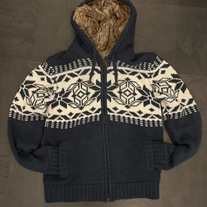 Stickad Hoodie (fodrad med päls) - Säljer en mysig mörkblå stickad hoodie med ett snyggt mönster, perfekt nu till våren! Storlek L men sitter som M Tröjan är endast använd ett fåtal gånger och har inga defekter (10/10 skick!)🔥