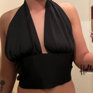 Svart halterneck topp från Gina Tricot  - Snygg svart halterneck topp från Gina Tricot med knytning i nacken och ryggen. 