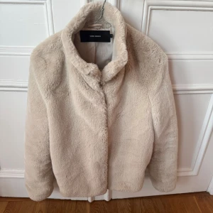 Beige pälsjacka från Vero Moda - Säljer en supermjuk och stilren beige pälsjacka från Vero Moda. Riktigt snygg på vintern och skönt med en högre krage. Tveka inte på att höra av dig vid fler frågor!