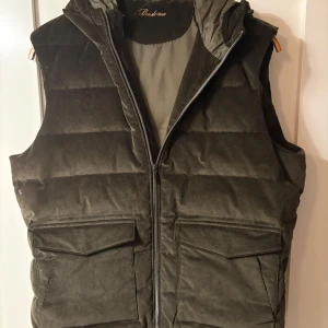 Grön manchester dunväst från Sten Ströms  - Snygg grön manchester dunväst från Lands' End med dragkedja och huva. Perfekt för kyliga dagar med sin quiltade design och praktiska fickor framtill.